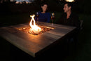 couple sitting in front of fire pit during night time