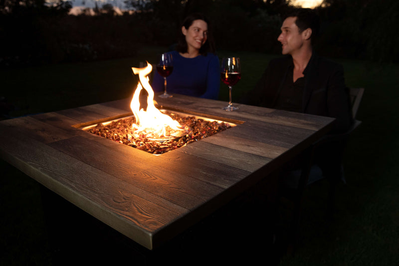 couple sitting in front of fire pit during night time